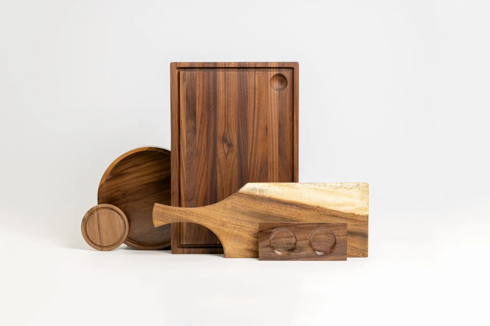 Colección de tablas artesanales de madera Lumberjack: tabla de nogal con canal, charola redonda, posavasos y paddle