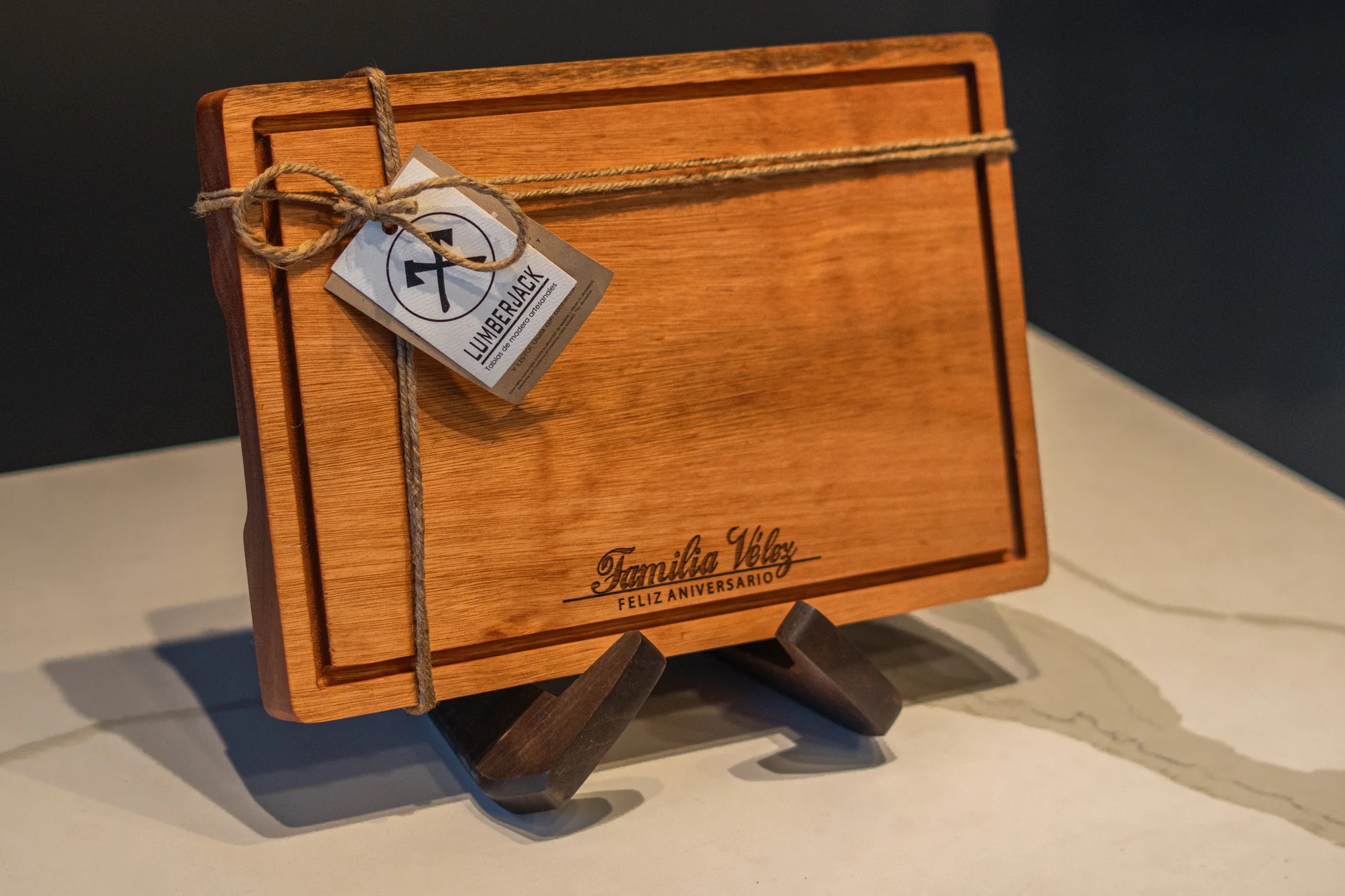 Tabla de madera con el grabado personalizado «Familia Vélez» y etiqueta de regalo